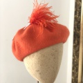 orange beret with feather hat pin
