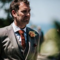 groom wearing tweed and a paper flower