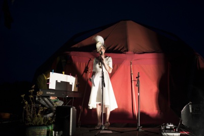 bride on stage still wearing her hat