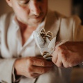 groom attaching his buttonhole pin