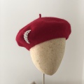 red beret with one moon brooch