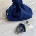 navy silk bag and feather hair clip