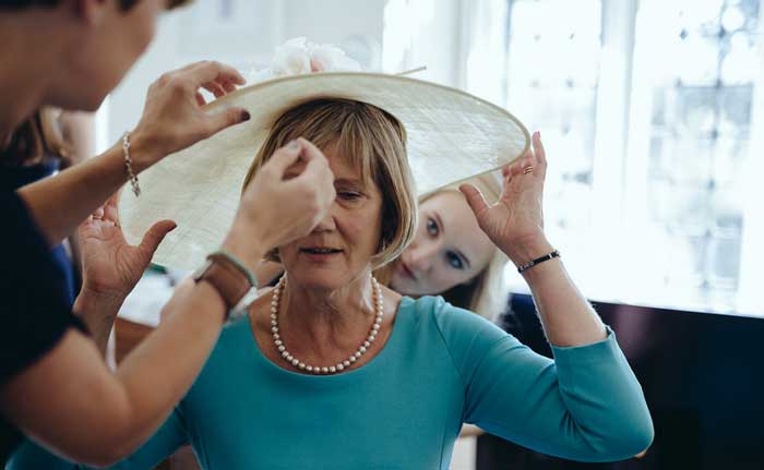 mother of the bride gets ready with hat